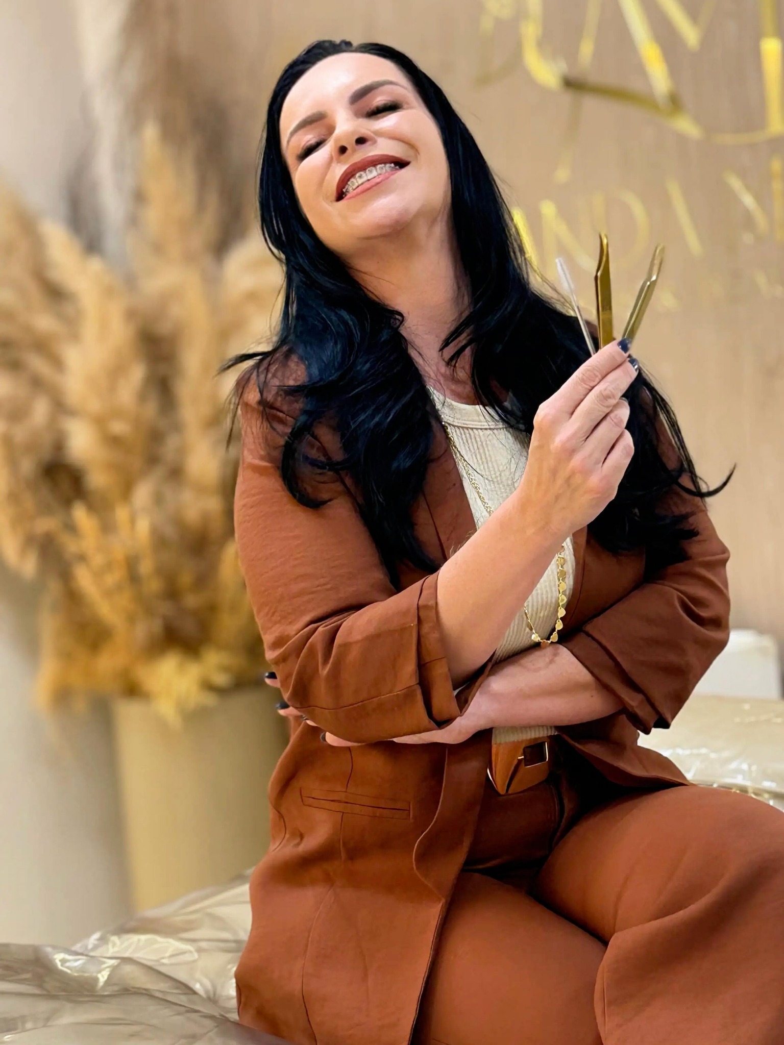 Amanda Mota no estúdio, segurando suas pinças de trabalho