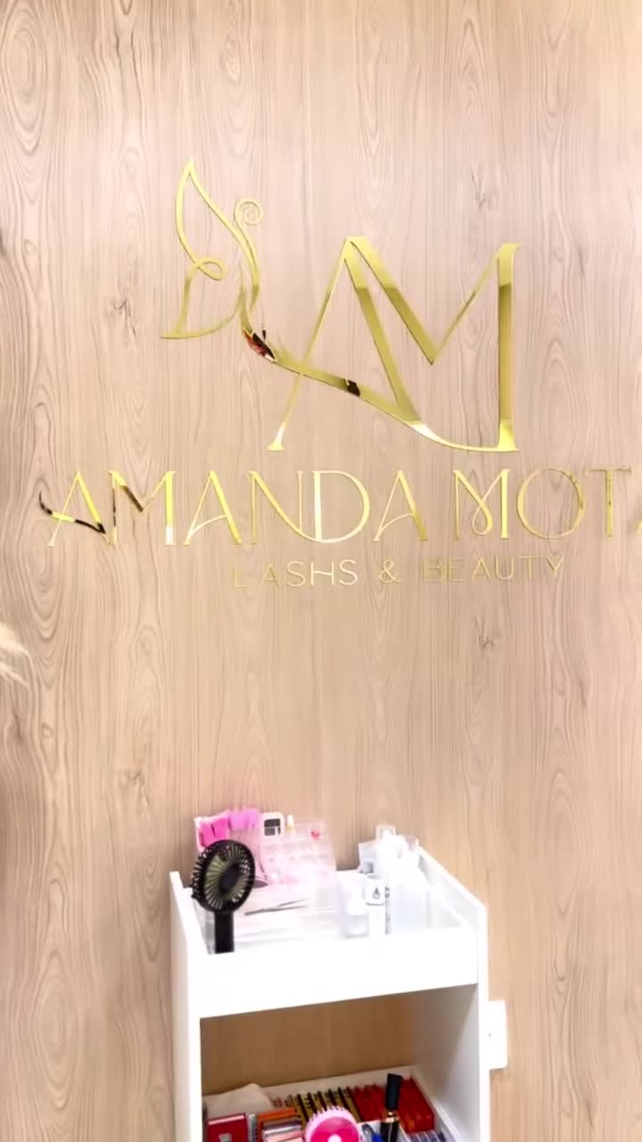 Detalhes do estúdio com a marca Amanda Mota e decoração em tons amadeirados