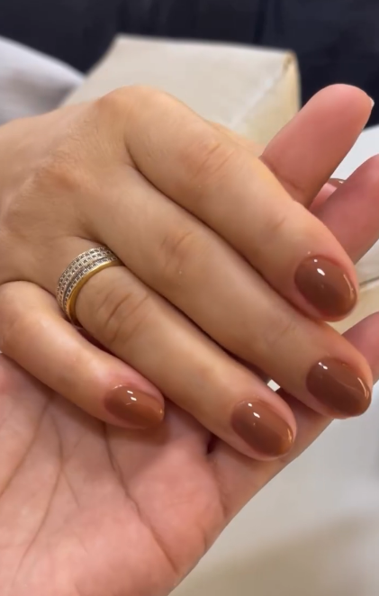 Unhas com esmaltação marrom e acabamento brilhante